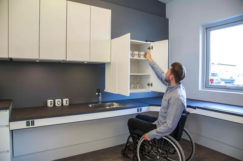 Wheelchair-accessible kitchen layout with open space and reachable storage 