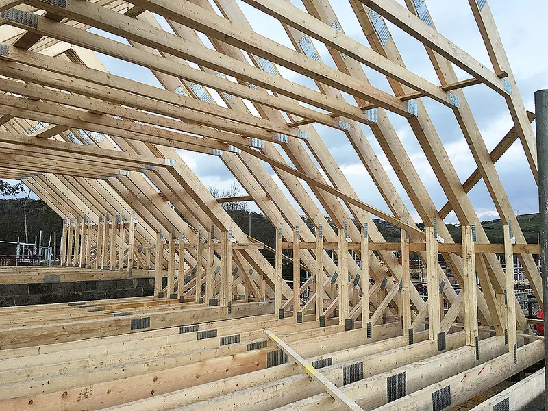 Truss roof construction with insulation and support beams visible 
