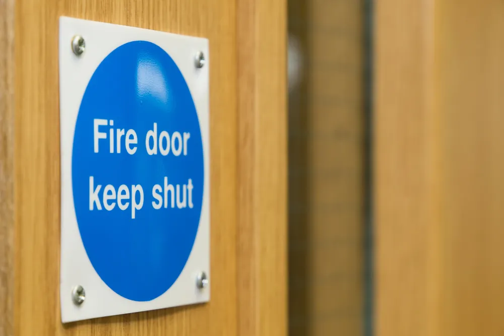 Official fire door signage fixed to timber door 